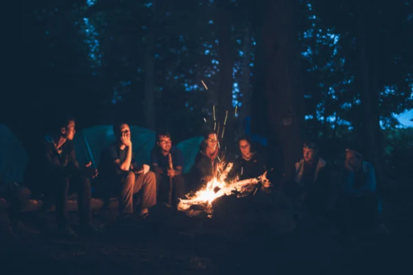 A group of people sitting around a fire.