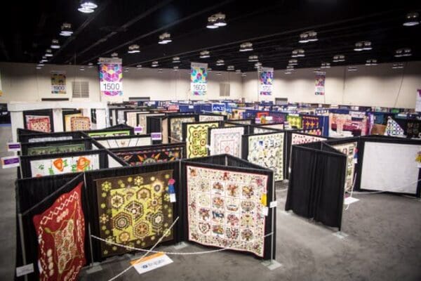 A room filled with lots of different types of quilts.