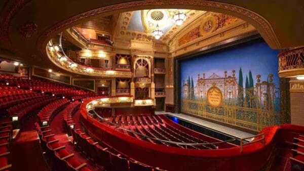 A theater with red seats and a large screen.