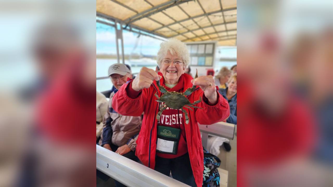 A woman in red jacket holding up two fingers.