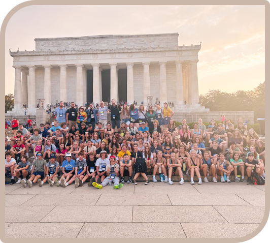 A group of people standing in front of the lincoln memorial.