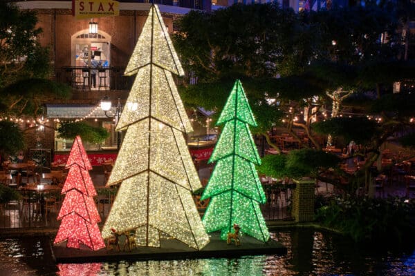 Lighted Christmas trees by the river.