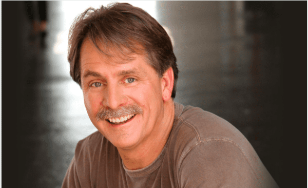 Headshot of a smiling man with a mustache.